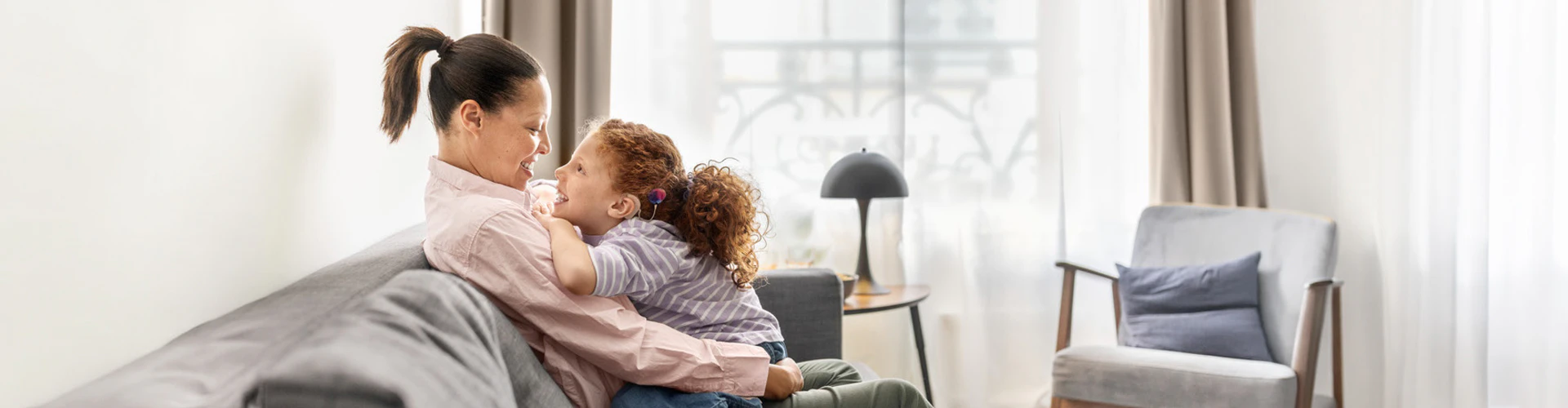 Mother and daughter looking at each other on the couch, daughter has a CI and SONNET 3
