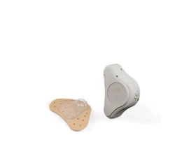 ADHEAR bone conduction device with accompanying adhesive adapter.