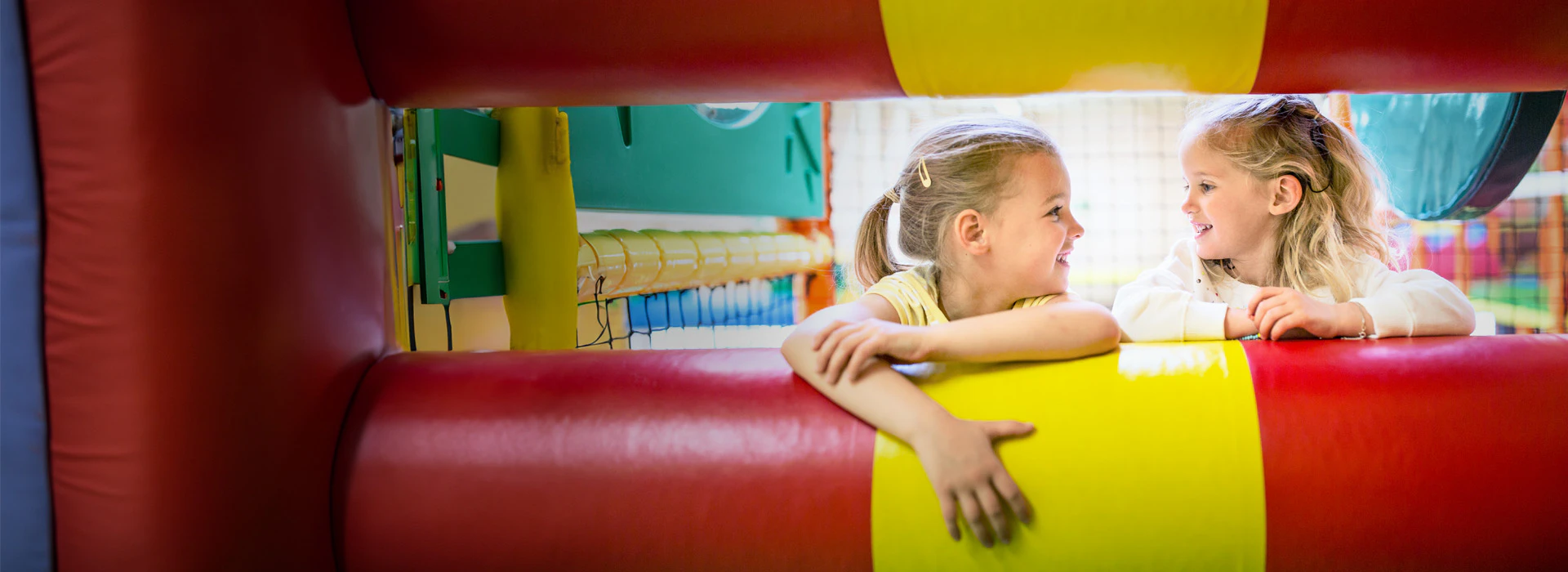 two little girls looking at each other in a play house