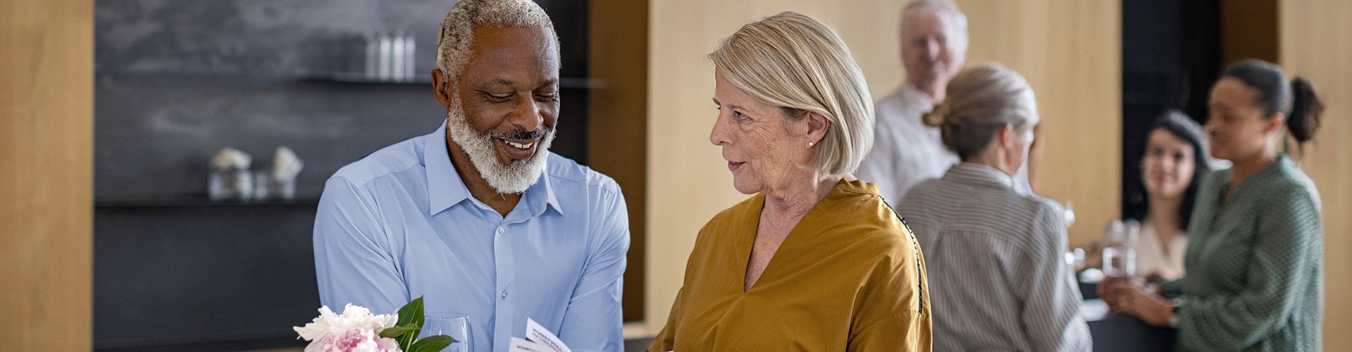 Um usuário mais velho do SONNET 3 curte uma conversa em um evento movimentado